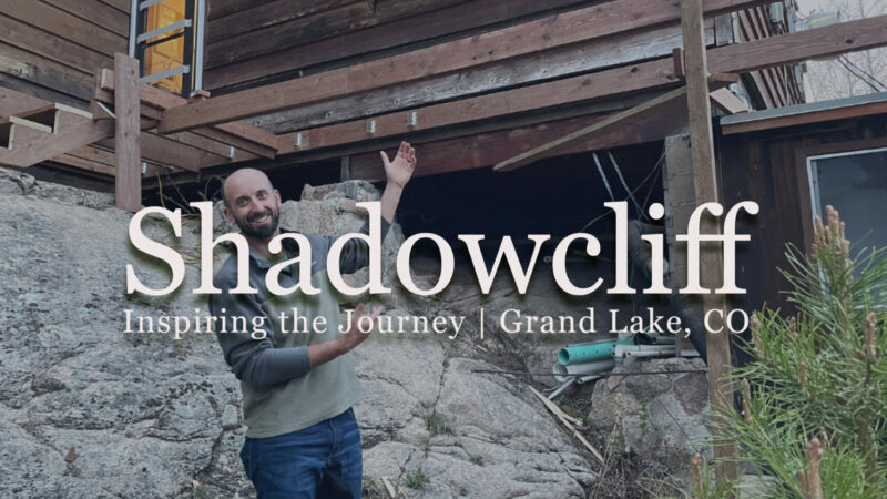 Background image is of a man smiling and gesturing toward a deck-building project behind him. Text over top says "Shadowcliff: inspiring the Journey, Grand Lake CO"